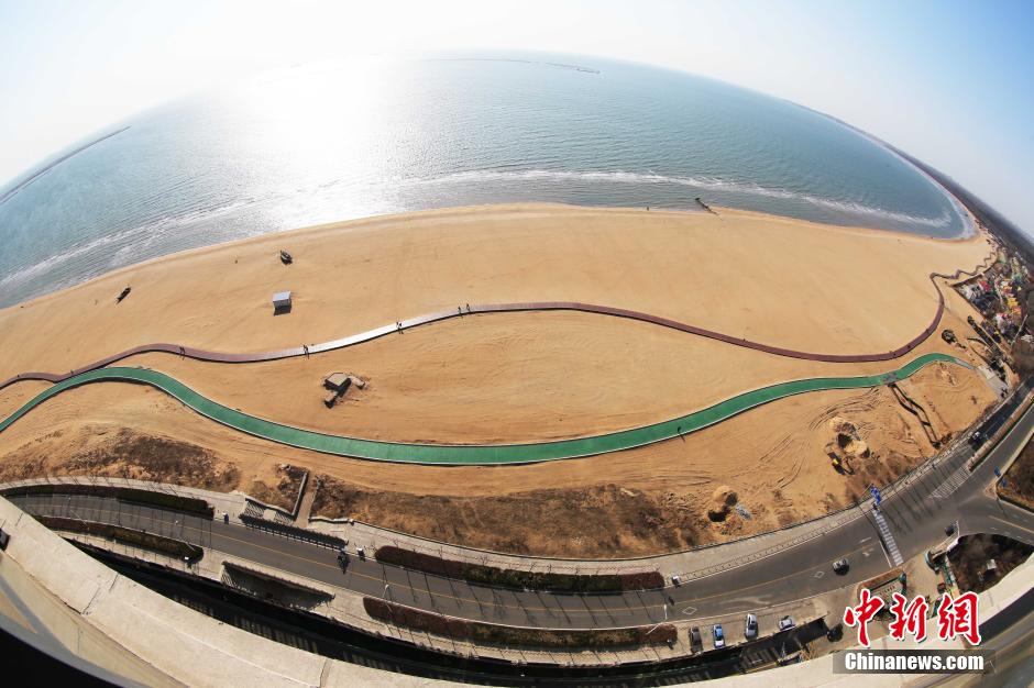 3月13日，秦皇島萬米臨海沙灘木棧道。據(jù)了解，該木棧道全長約4200米，與北戴河區(qū)原有的7500米木棧道對接后全線總長度1.17萬米，整個木棧道東起秦皇島體育基地游船碼頭，西至北戴河濕地公園，呈波浪形蜿蜒10.4公里海岸線。 中新社發(fā) 曹建雄 攝 CNSPHOTO